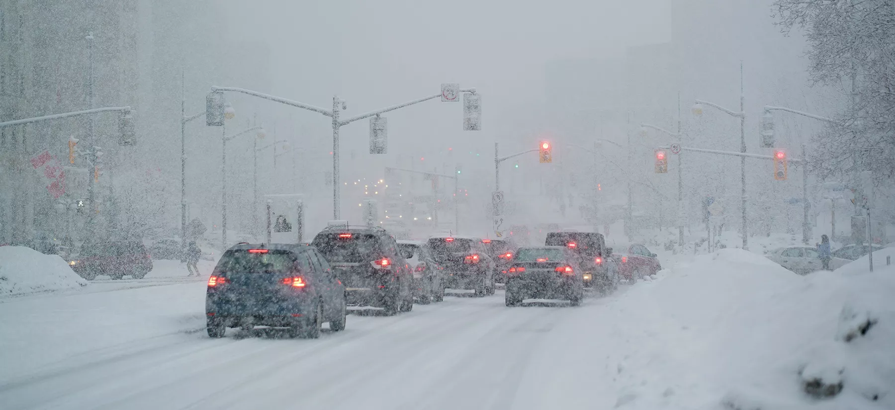 Image of city traffic moving slowly through snowy conditions.